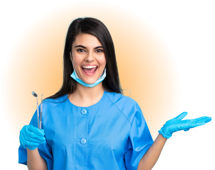 Smiling woman in blue scrubs and gloves holding dental tools, with a mask under her chin.